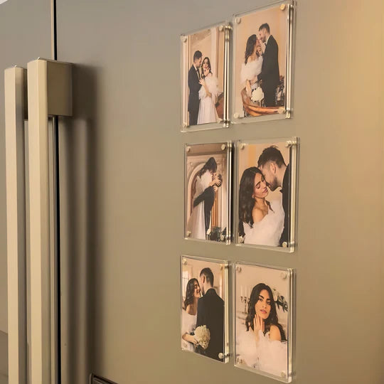 Set of six clear photo frames with wedding-themed images attached to a refrigerator.