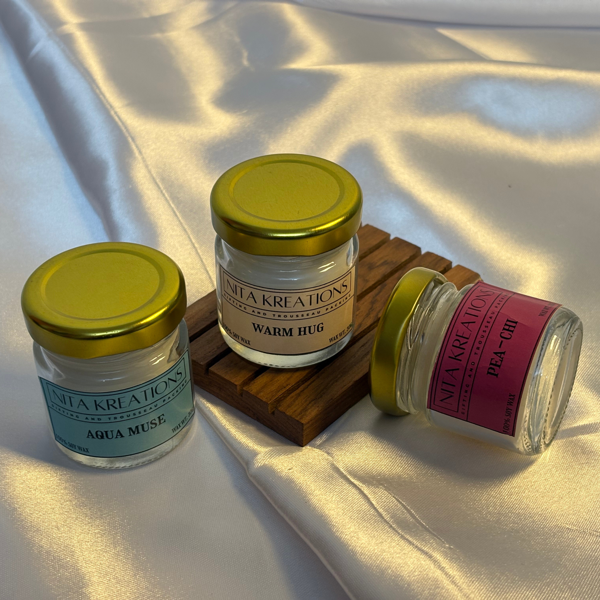 Pack of 3 mini soy candles in amber jars featuring Warm Hug, Pea-chi and Aqua Muse fragrances, named Sun-Kissed Breeze.